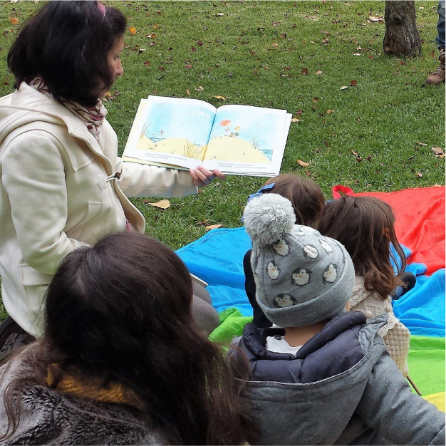 Leitura de livro ao ar livre para várias crianças